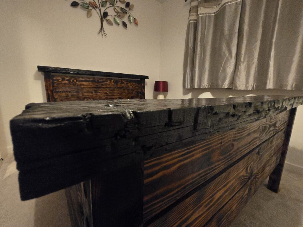 Handmade wooden bed with burnt wood