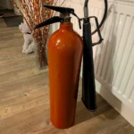 Alternative rear angle of fire extinguisher candle holder #3 showing the red body and retained black fittings.