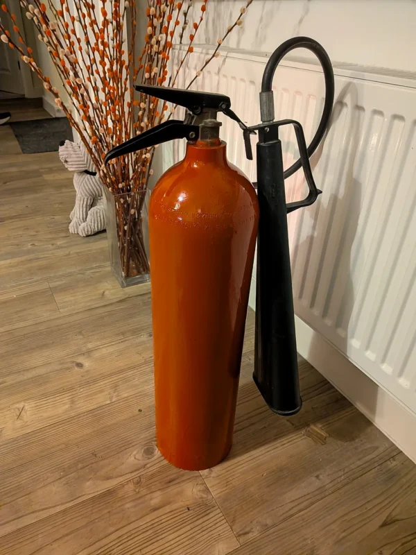 Alternative rear angle of fire extinguisher candle holder #3 showing the red body and retained black fittings.