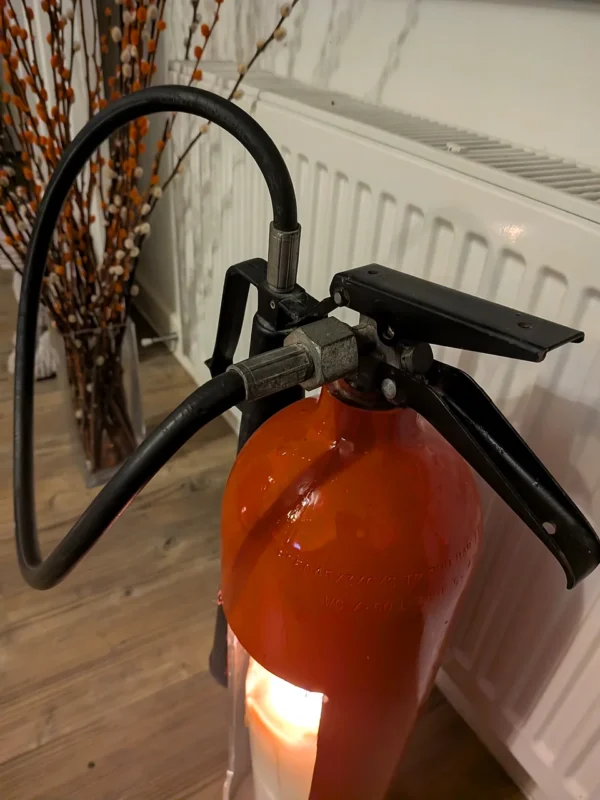 Close-up of the original black handle and hose connection on fire extinguisher candle holder #3.