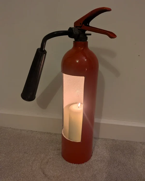 Angled view of fire extinguisher candle holder #8 showing the white-painted interior and candle opening.