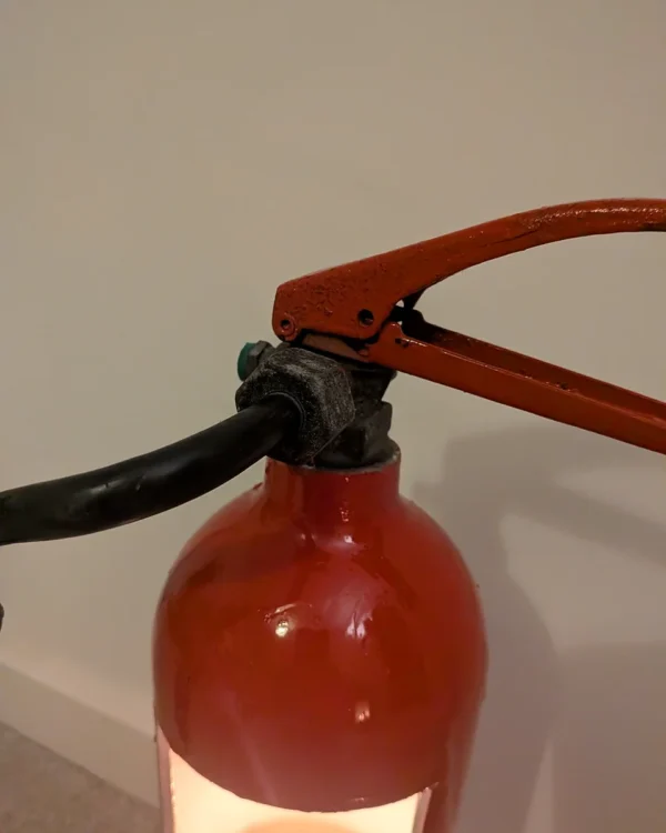 Close-up of the original handle, valve and red shoulder of upcycled fire extinguisher candle holder #8.